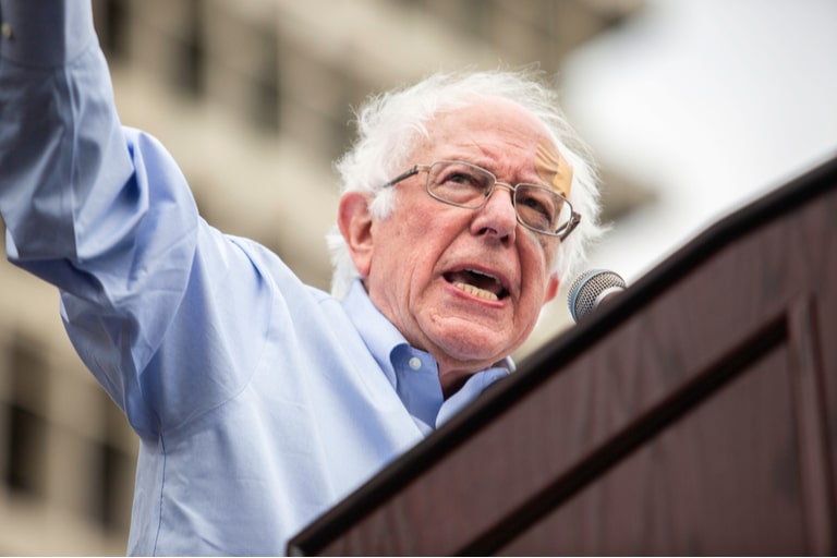 Bernie Sanders standing while giving a speech